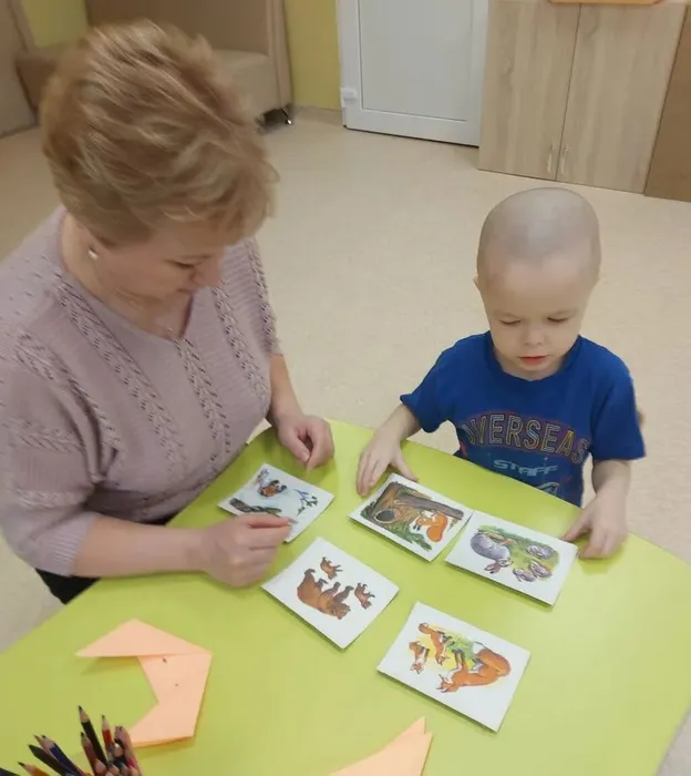 Воспитанник рассматривает картинки про диких животных