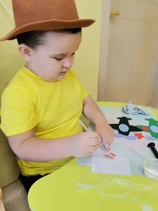 Ребёнок наносит клей на звёздочку