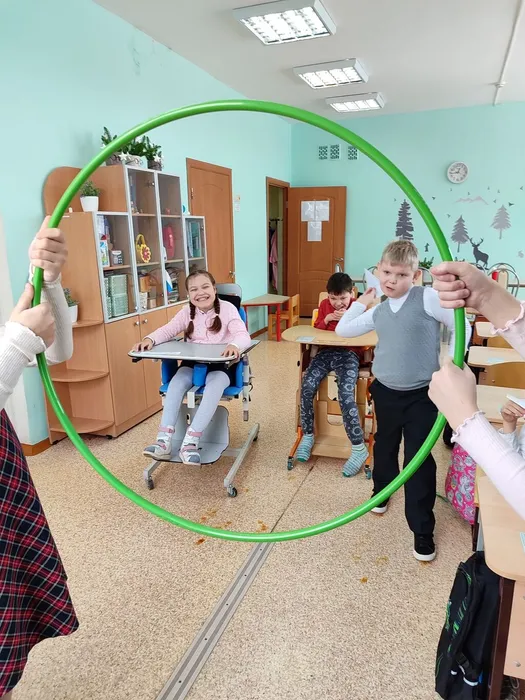 Ученик 1С запускает бумажный самолётик в обруч