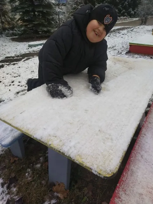 Мальчик играет со снегом