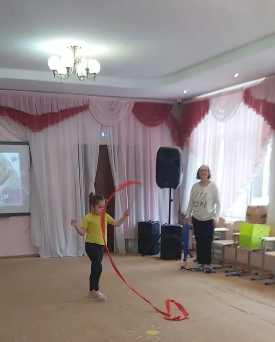 Ребёнок выполняет упражнение с лентой