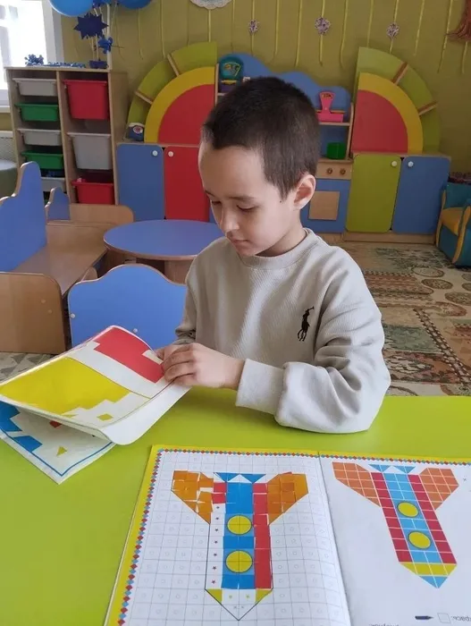 Ребенок мастерит ракету в технике Аппликация