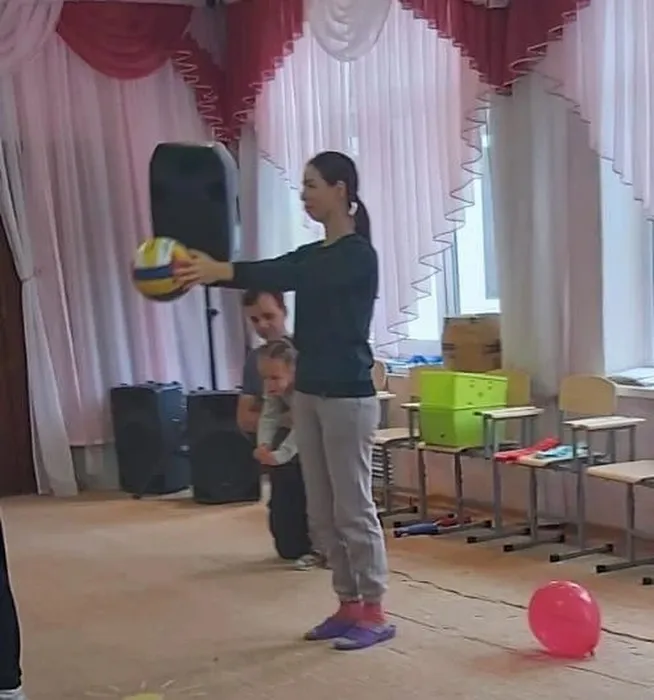 Мама выполняет упражнение с мячом