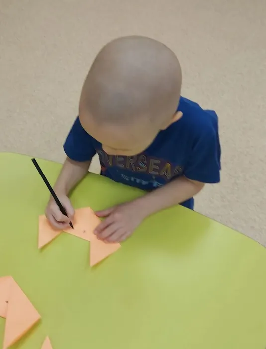 Ребенок дорисовывает маску лисы