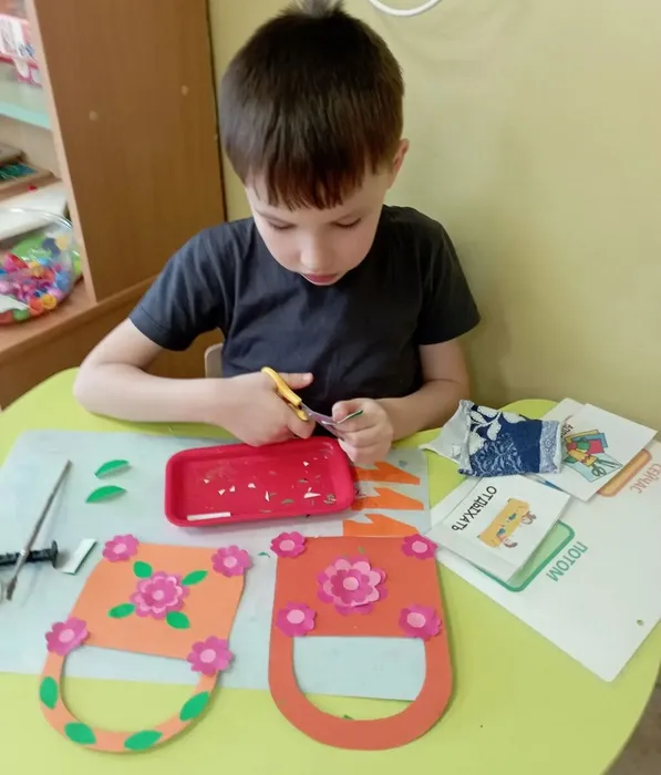 Ребёнок приклеивает цветок