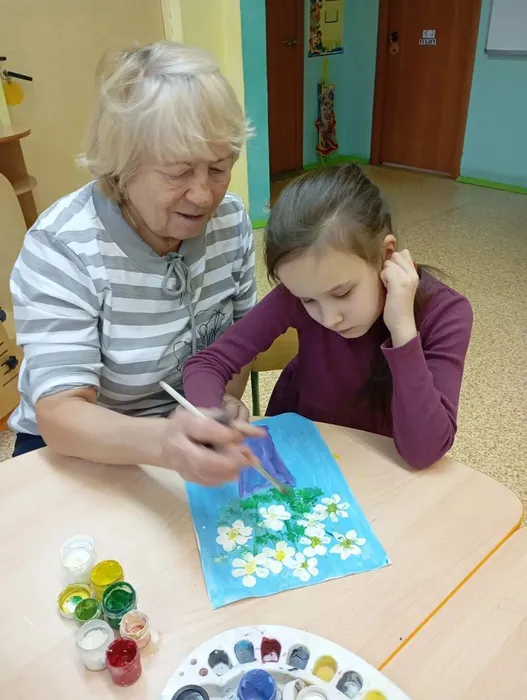 Воспитатель помогает ребенку рисовать