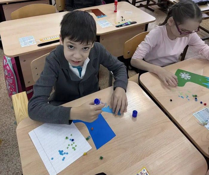 Ученик клеит поделку