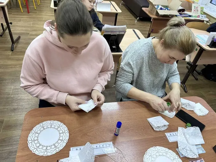 Родители готовят заготовки для снежинок