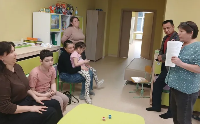 Педагог демонстрирует родителям технику нетрадиционнго рисования