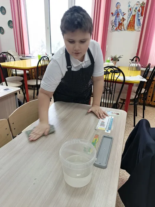 Школьник протирает парту