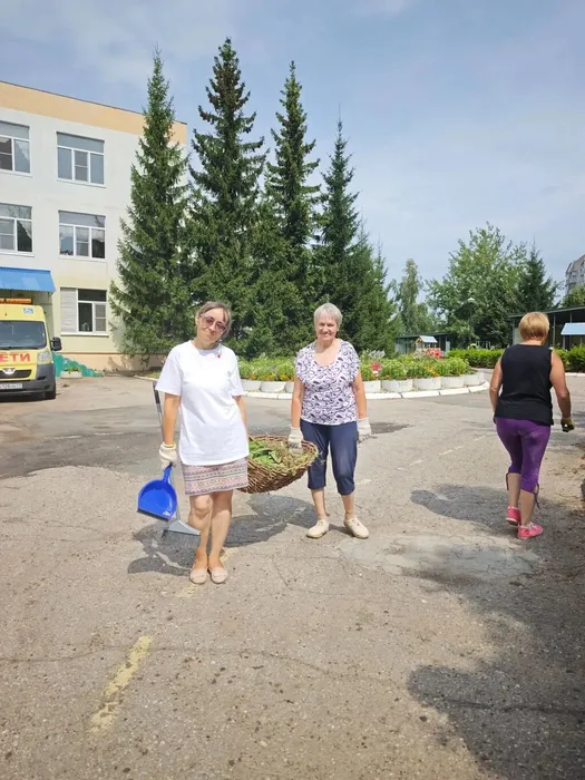 Педагоги несут сорняки на мусорку