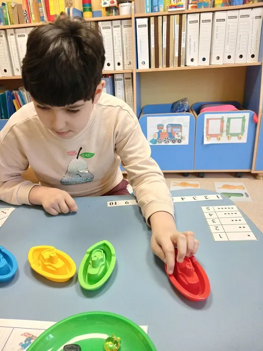 Девочка раскладывает предметы по цветам