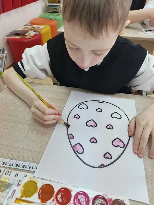Ученик красит яицо