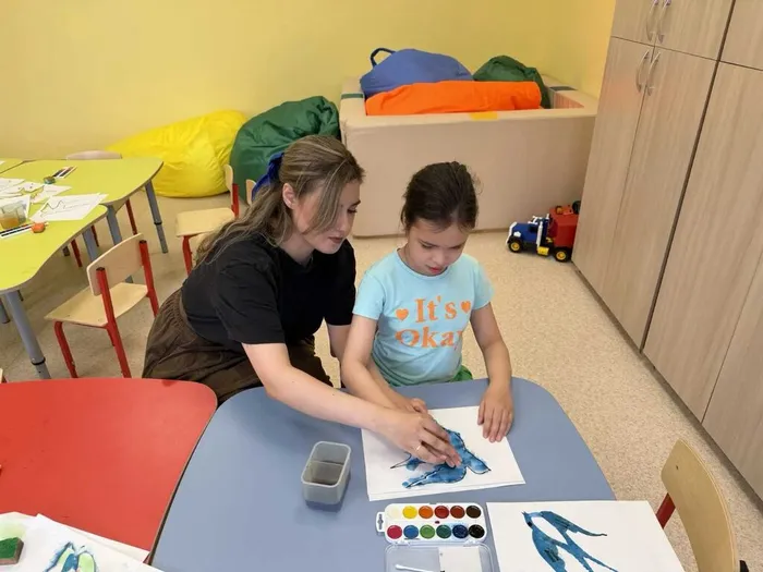 Педагог помогает нарисовать ребенку ласточку