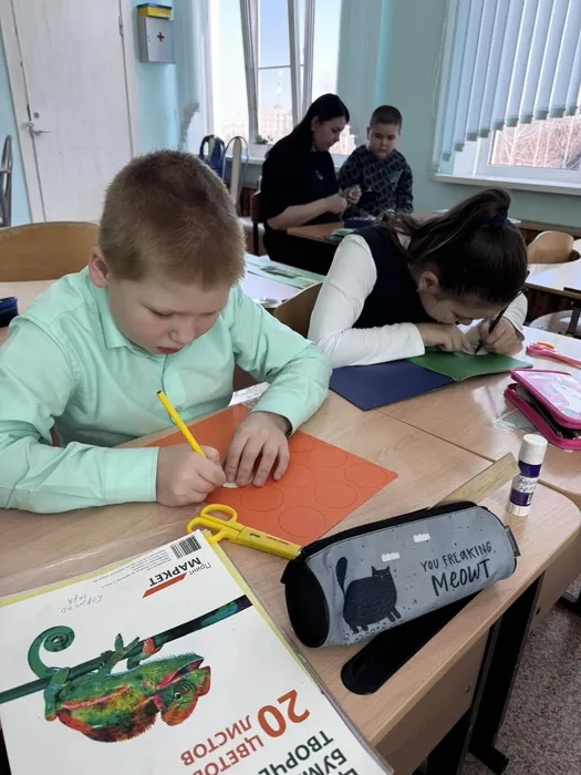 Ученики обводят по шаблону кружочки на цветной бумаге