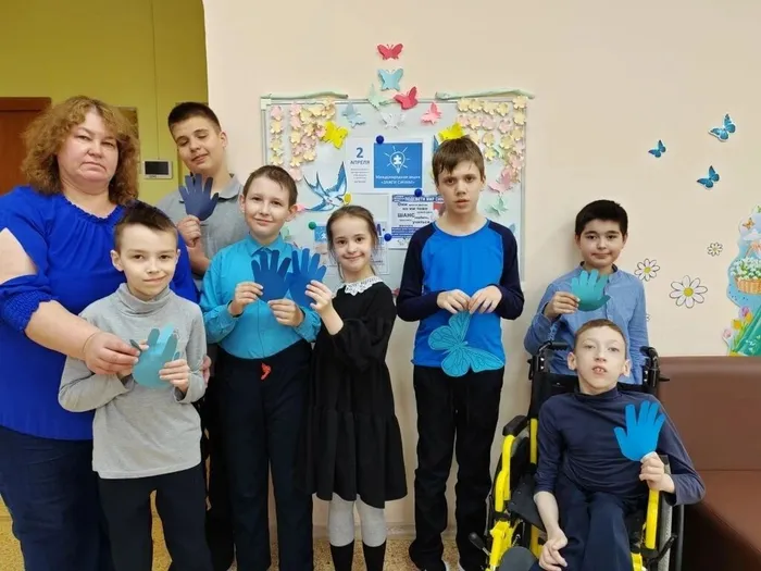 Ученики 4 В класса держат в руках синие ладошки