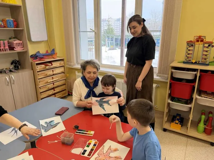 Ребенок показывает готовый рисунок другому ребенку