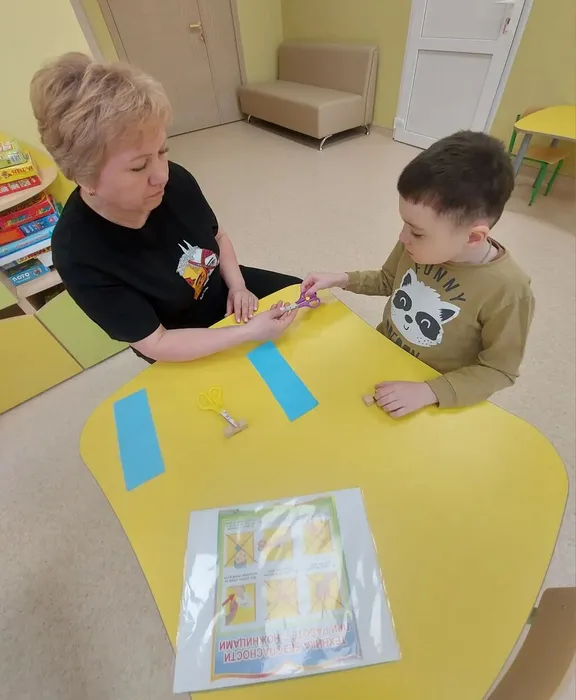 Педагог группы Солнышко закрепляет с ребенком правила пользования ножницами