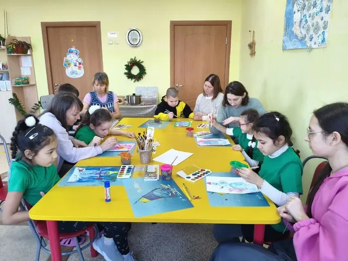 ученица выполняет работу, клеит детали снеговика