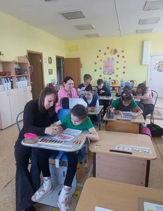 Учащиеся и родители раскрашивают пасхальные яйца