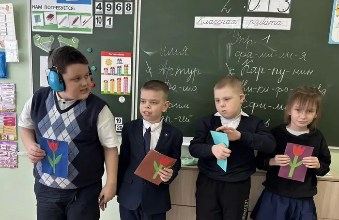 Ученики 2 «И» класса фотографируются с открытками для мам