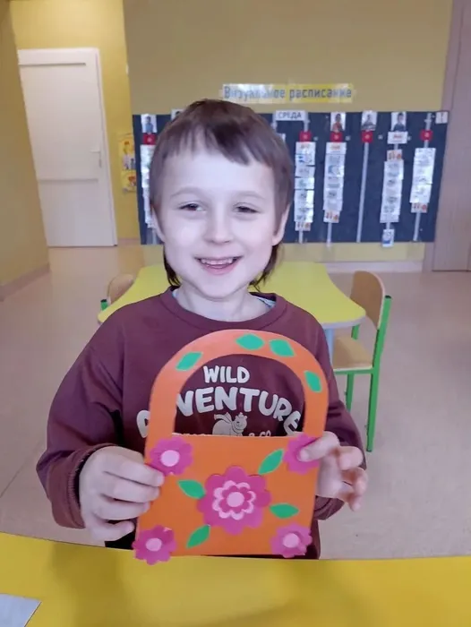 Ребёнок держит творческий подарок для мамы
