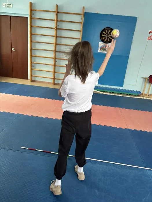 Ученица 2 И класса бросает мяч в мишень