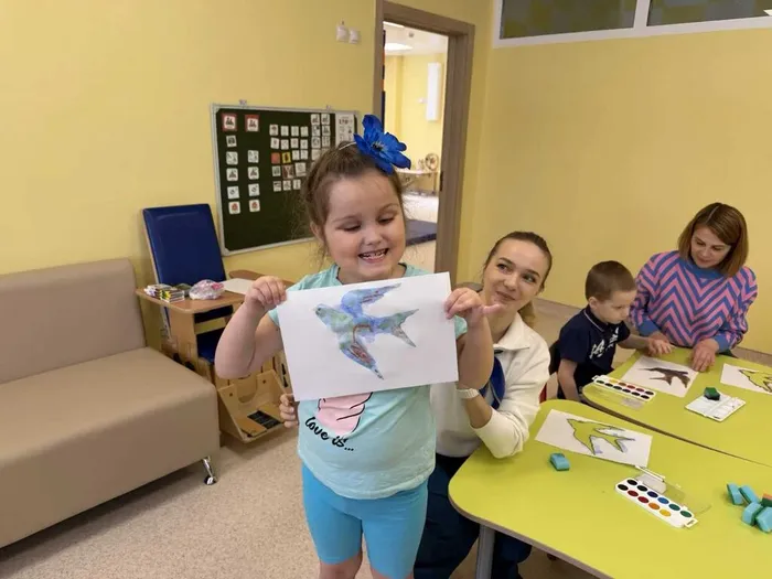 Ребенок показывает готовый рисунок ласточки