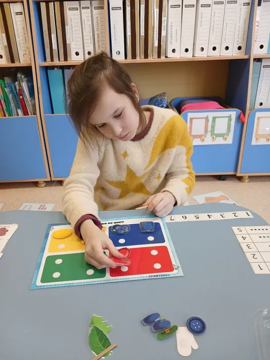Девочка выполняет  на занятии игровой прием Цветное лото