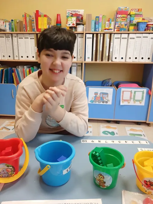 Девочка выполняет  на занятии  упражнение Цветные ведёрки